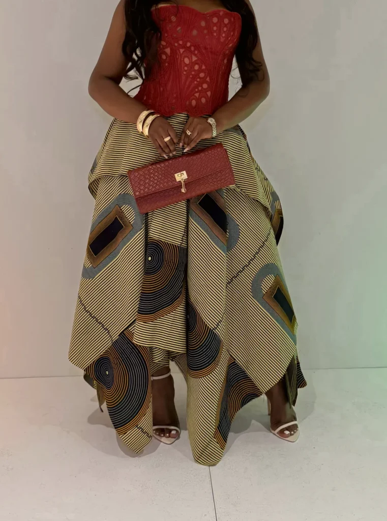 Red lace corset, kitenge skirt and a red clutch